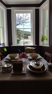 een tafel met borden en borden met een raam bij Montagu Manor in Montagu