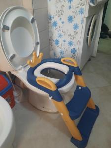 a bathroom with a toilet with a blue seat at Pine Apartment 2 plus 1 in Golem +47 photos