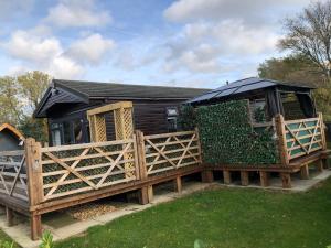 a house with a wooden gate and a fence at Peaceful Holiday Lodge with Hot Tub in Lincolnshire