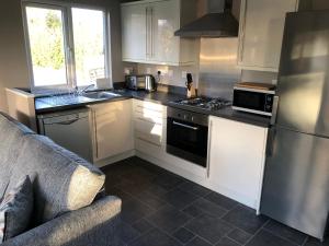 a kitchen with white cabinets and a stove top oven at Peaceful Holiday Lodge with Hot Tub in Lincolnshire