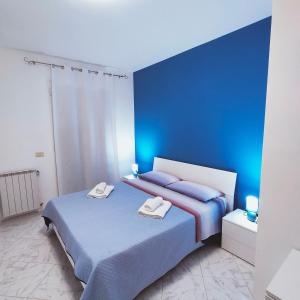 een slaapkamer met 2 bedden en blauwe muren bij Appartamento Rosariomaria in Realmonte