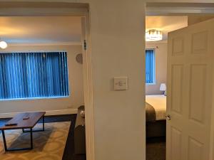 um quarto com uma cama, uma mesa e uma porta em Racecourse Apartment em Doncaster