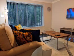 sala de estar con sofá y mesa en Racecourse Apartment, en Doncaster