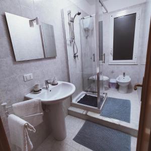 een badkamer met een douche, een wastafel en een toilet bij Appartamento Rosariomaria in Realmonte