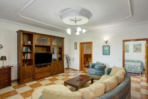 a living room with a couch and a tv at Casa Mariposa in Valsequillo