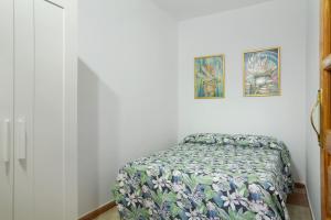 1 dormitorio con 1 cama y 2 cuadros en la pared en Casa Mariposa, en Valsequillo