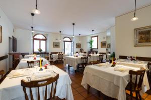a dining room with tables with white tablecloths at Locanda Piemonte da Sciolla in Domodossola