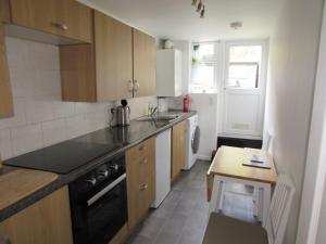a kitchen with a sink and a stove top oven at The Cuddy - Apartment with garden in Brixham