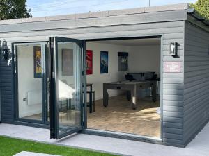 a grey shed with a patio and a table at 145 New Road in Porthcawl
