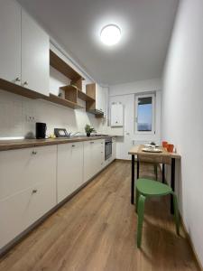 a kitchen with a table and a green stool at Luxury Q Residence near Palas Mall in Iaşi