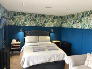 a bedroom with blue walls and a bed with towels on it at The Rhossili bay secret in Swansea