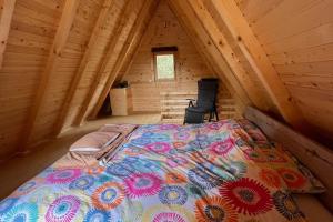 a large bed in a wooden cabin with a attic at Cozy Forest Hut near Sarajevo in Pale