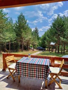 a table and chairs on a patio with a view of a park at Cozy Forest Hut near Sarajevo in Pale