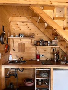 una cocina con fregadero en una cabaña de madera en Cozy Forest Hut near Sarajevo, en Pale