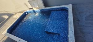 a swimming pool with blue water in a concrete tub at Casa em Caldas Novas in Caldas Novas