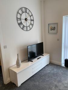 a living room with a tv and a clock on the wall at The office at the old Forge 