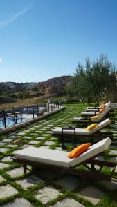 une rangée de chaises longues assises sur l'herbe dans l'établissement MDC Cave Hotel Cappadocia, à Ürgüp