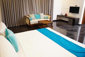 um quarto de hotel com uma cama e um sofá em Village Hotel Northern Point em Point Pedro