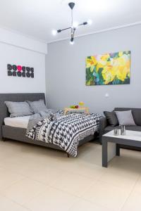 a bedroom with a bed and a couch and a painting at K6 Fashion Sparta Apartment in Sparta
