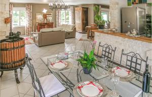 Savignac-les-ÉglisesにあるAmazing Home In Savignac Les Eglises With 3 Bedrooms, Wifi And Outdoor Swimming Poolのリビングルーム(ガラスのテーブル、椅子付)