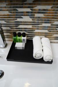 un mostrador con dos rollos de toallas de papel en una bandeja negra en Village Hotel Northern Point en Point Pedro