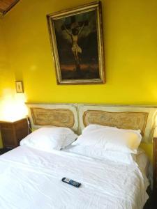 Un dormitorio con una cama blanca con una foto en la pared en BeB LE CASE ROSSE, en Verucchio