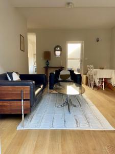 ein Wohnzimmer mit einem Sofa und einem Tisch in der Unterkunft GÎTE DE LA MUSARDE in Villers-sur-Mer