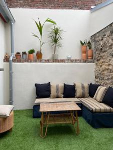 ein Wohnzimmer mit einem Sofa und Topfpflanzen in der Unterkunft GÎTE DE LA MUSARDE in Villers-sur-Mer