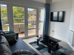 ein Wohnzimmer mit einem Sofa und einem Flachbild-TV in der Unterkunft BayVue Apartment & Apartment 7, The Bay House in Shanklin