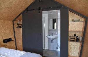 een badkamer met een wastafel en een spiegel bij Tenthuisje in het groen, een suite met eigen badkamer in Callantsoog