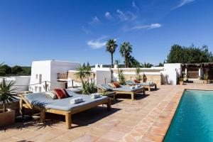 a patio with chaise lounges and a swimming pool at Elegant Restored Luxury 600 Year Old Farmhouse I Las Chumberas I 6 Bedrooms I Stunning Views I Santa Gertrudis in Santa Gertrudis de Fruitera