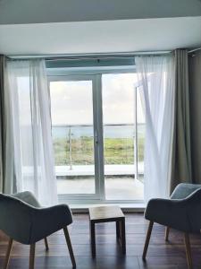 een woonkamer met een groot raam met uitzicht op de oceaan bij Vista Mara in Donegal