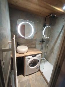 a small bathroom with a washing machine and a mirror at L'OURALOU - Vue panoramique in Les Gets