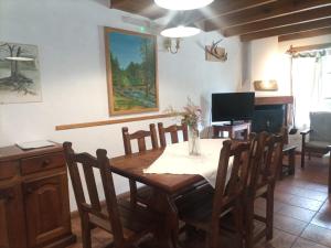jadalnia ze stołem, krzesłami i telewizorem w obiekcie Cabañas Trabunche w mieście San Martín de los Andes