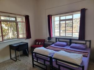 ein Schlafzimmer mit zwei Betten, einem Stuhl und zwei Fenstern in der Unterkunft Rainbow Guest House in Amman + 67 Fotos