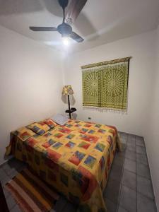 Un dormitorio con una cama y una lámpara. en Apto 16 - Aconchegante - Praia das Astúrias - Guarujá - SP, en Guarujá