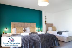 um quarto com 2 camas e uma parede verde em Syster Properties Leicester large home for Contractors, Families , Groups em Leicester