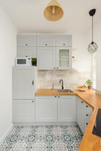 una cocina con armarios blancos y fregadero en The Grassmarket Apartment, en Edimburgo