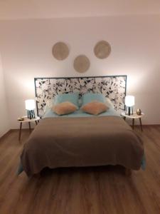 1 dormitorio con 1 cama grande y 2 lámparas en Gîte "Au dépôt" en Mesnières-en-Bray
