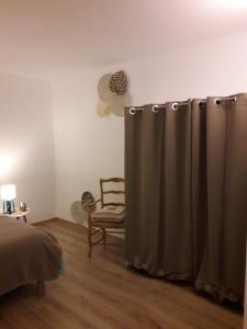 1 dormitorio con cortina de ducha y silla en Gîte "Au dépôt" en Mesnières-en-Bray