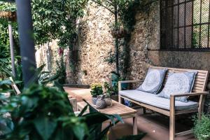 un patio con un banco y una mesa con almohadas en Picaza del Jerte, en Cabezuela del Valle