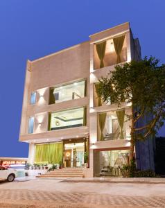 um edifício com um carro estacionado em frente em Hotel Avalon Palms Agra em Agra