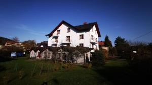 a large white house sitting on top of a lush green field at Dom Wczasowy Irys in Węgierska Górka