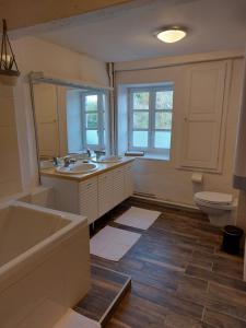 a bathroom with a tub and a sink and a toilet at La cambuse des gones - Gîte 3 chambres in Thurins