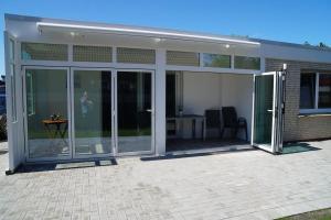 an extension of a house with sliding glass doors at Küsters Ferienhaus Tinchen in Norden