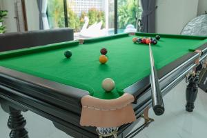 een snookertafel met een keu en ballen erop bij Bonita Pool Villa in Buriram