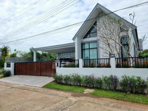 una casa blanca con una puerta y una valla en Bonita Pool Villa en Buriram