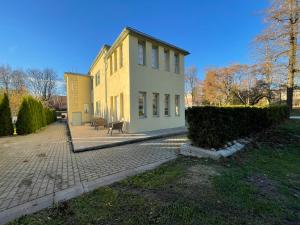 ein großes gelbes Haus mit einer Terrasse davor in der Unterkunft "Winter" Apartment in Viljandi