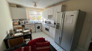 a kitchen with a stainless steel refrigerator and a table at Stunning 3-Bed Apartment in Croydon in Croydon