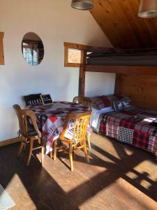 a room with two bunk beds and a table and chairs at Les Cabines Nordik 2.0 in Shawinigan